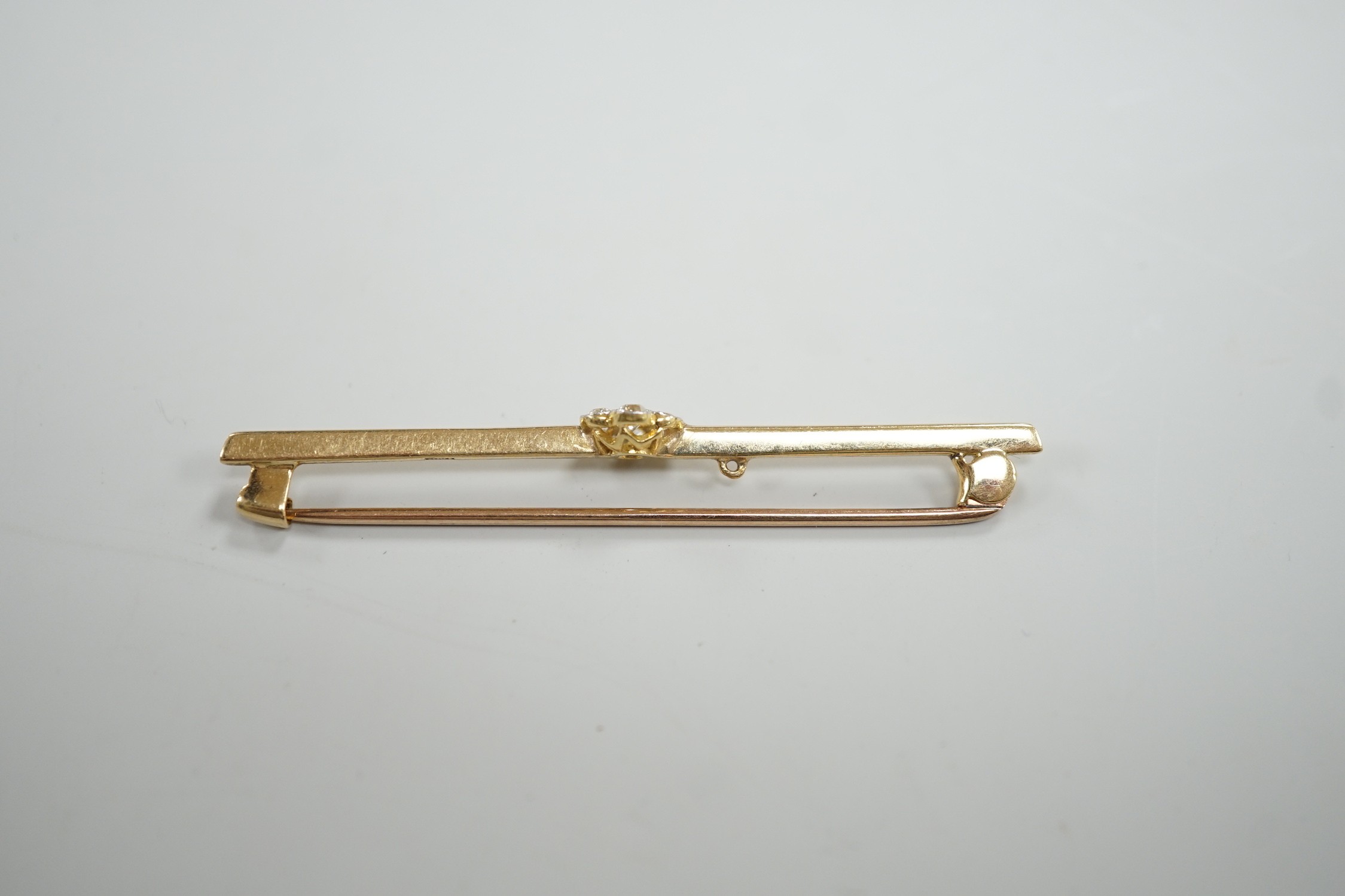 An 18ct and seven stone diamond set flower head cluster bar brooch, 57mm, gross weight 4.7 grams.